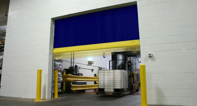 Blue fabric high-speed roll-up door open as a forklift moves a tote through the doorway