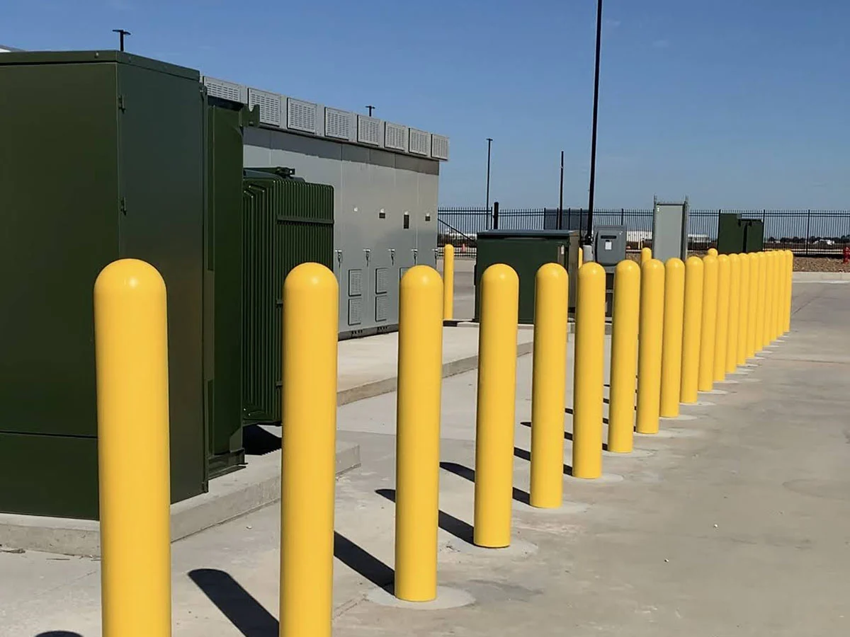Yellow steel safety bollards installed at a commercial facility