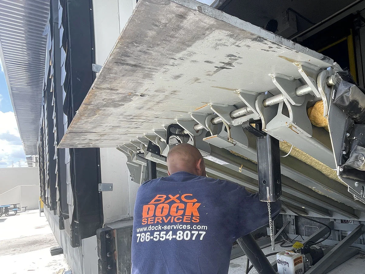 BXC Dock Services technician servicing a hydraulic pit dock leveler