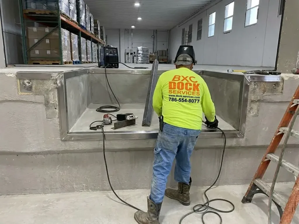 BXC technician welding the steel frame of a new dock leveler pit